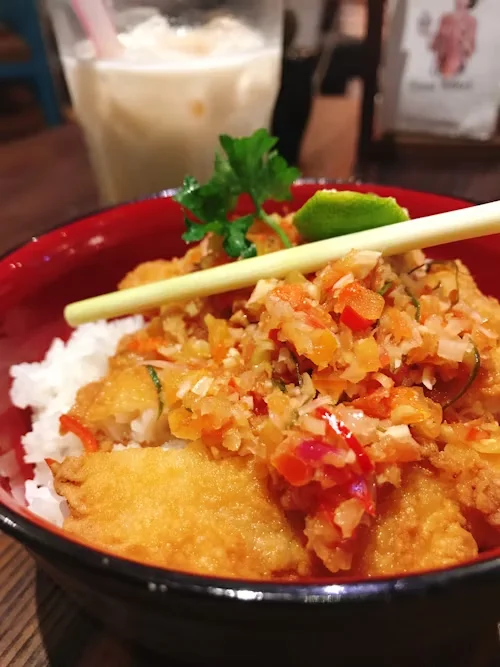 Onigiri in the bowl with a chopstick and garnishes
